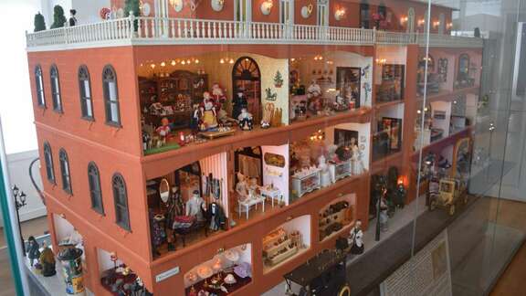 Großes Puppenhaus in Glasvitrine